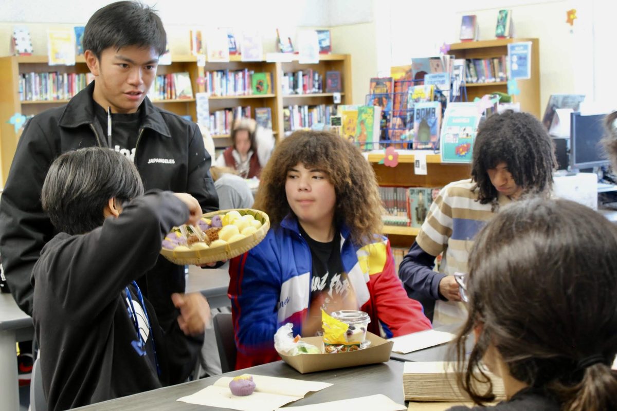 Filipino Club President Jakob De Leon serves traditional Filipino rice cakes called puto to members on March 22. During the clubs first meeting, students were invited to the library to enjoy some cultural treats and bond over their heritage.