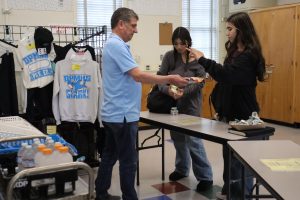 Financial Manager Farzad “Fred” Radparvar sells chips to junior Malaika Afridi on May 20. The student store sells an assortment of snacks such as chips, drinks, ice cream and cookies. Some of these foods include Red Dye 40, like the Hot Cheetos and red velvet cookies, which will be banned under AB418.