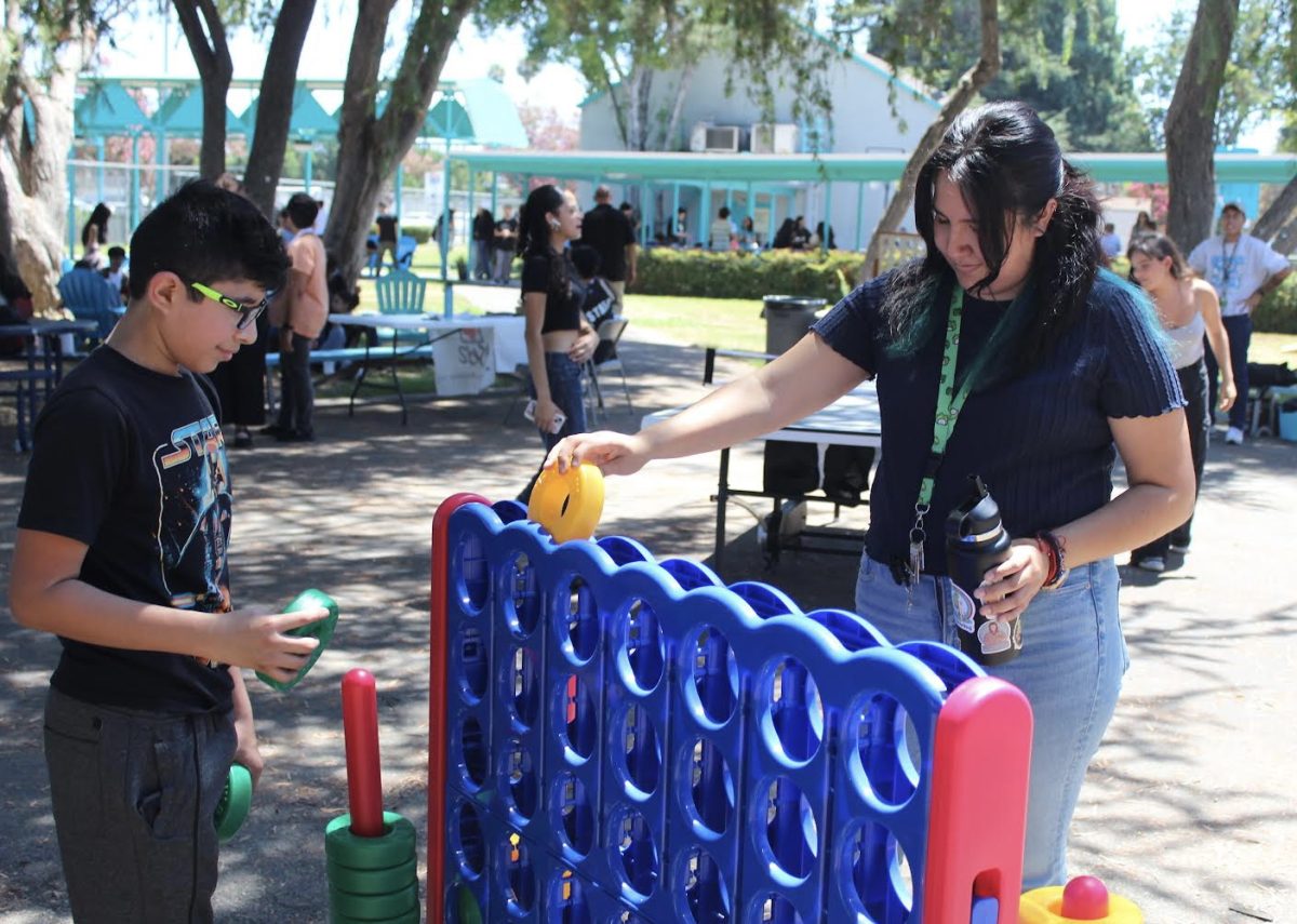 Sophomore Giancarlo Valdez and English teacher Valerie Quiroga play a game of Connect 4 during the first Fiesta Friday of the school year on Aug. 16.