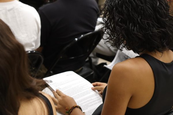 Senior Angela Mendoza reads over the senior contract during the school wide behavioral assembly held during period 2 in the MPR on Aug. 16. 