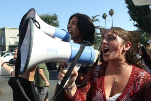 Junior Sebastian Olfatmanesh and senior Leeron Nakash shout chants into their megaphones during the walkout on Sept. 23. The walkout was held during period 6 to protest the reinstatement of music teacher Wes Hambright and Spanish teacher Glenda Hurtado.