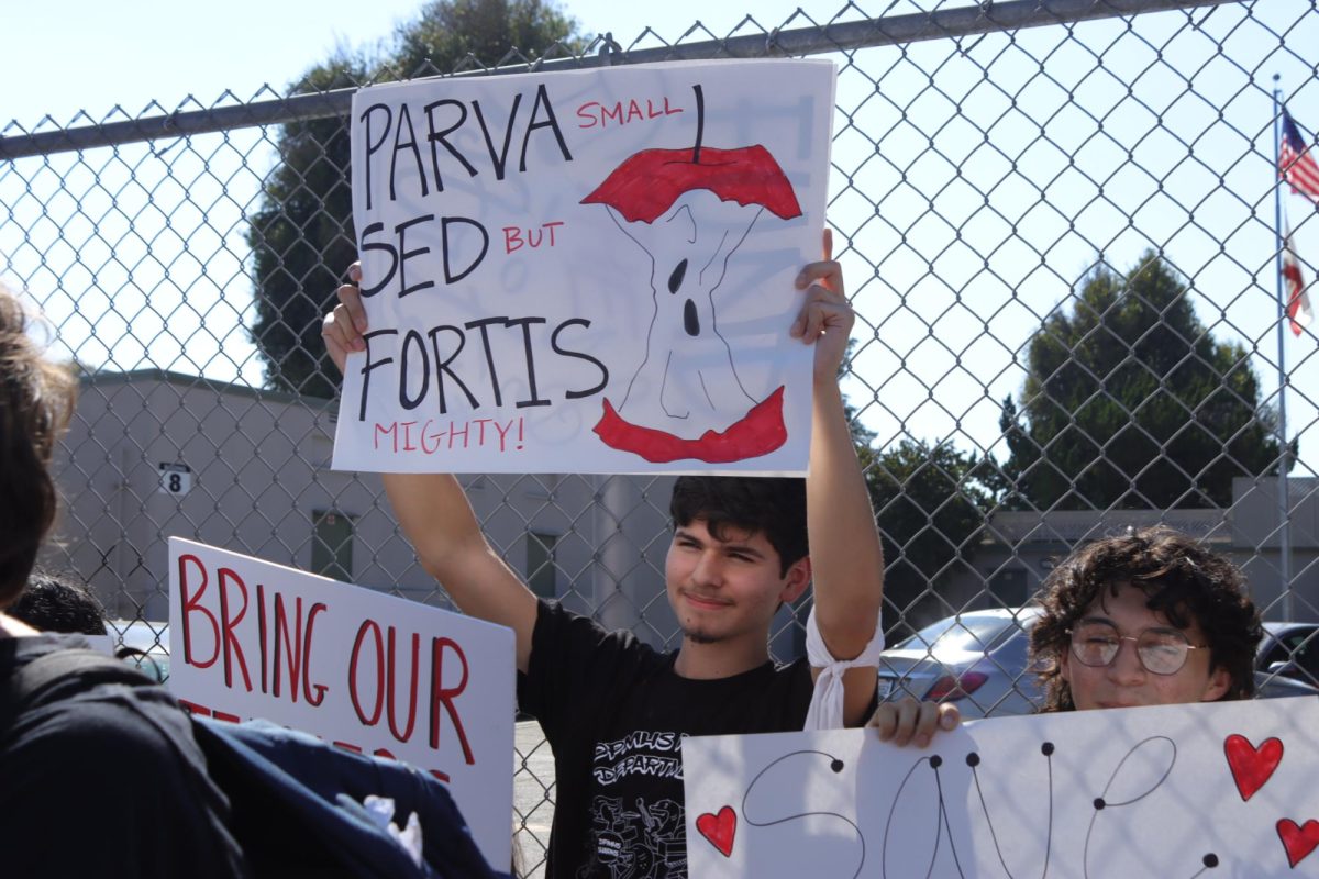 Sophomore Mateo Zazueta holds up a sign with the school motto as he protests for the reinstatement of recently displaced teachers Wes Hambright and Glenda Hurtado on Sept. 23.