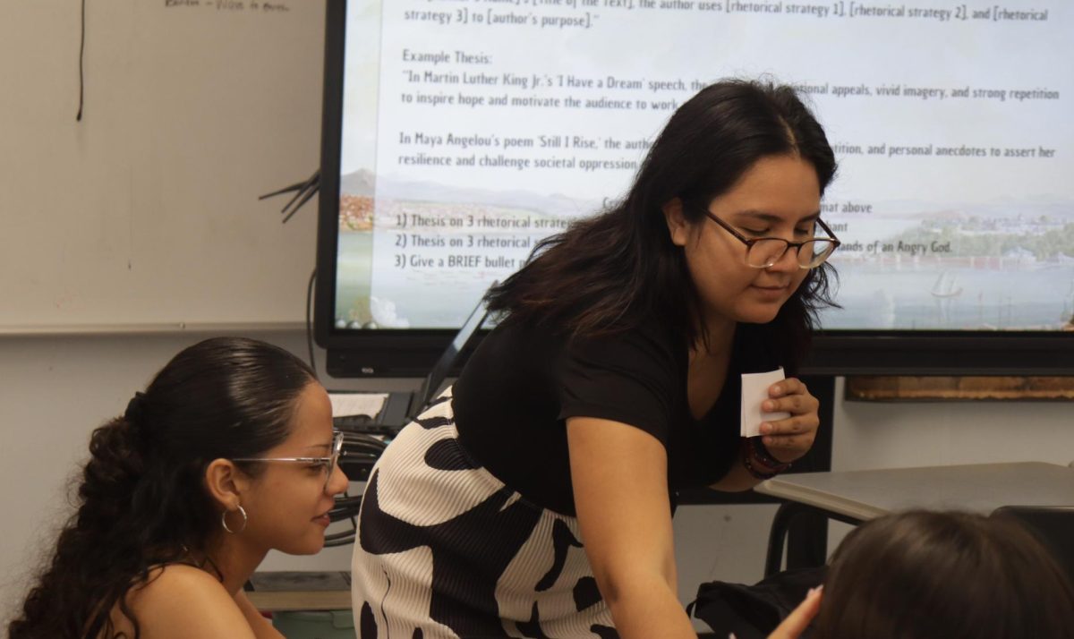 New English teacher Valarie Quiroga helps senior Allison Gonzalez with her thesis statement on Sept. 6. Students were assigned to write two thesis statements for their first half of class.