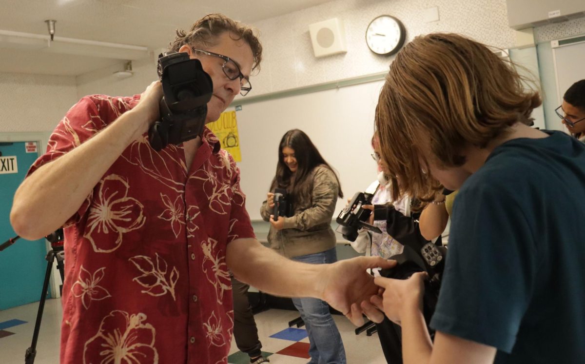 New video production teacher Tennessee Norton shows sophomore Sprout Robins-Yerke how to properly work a camera during period 2 on Sept. 17.