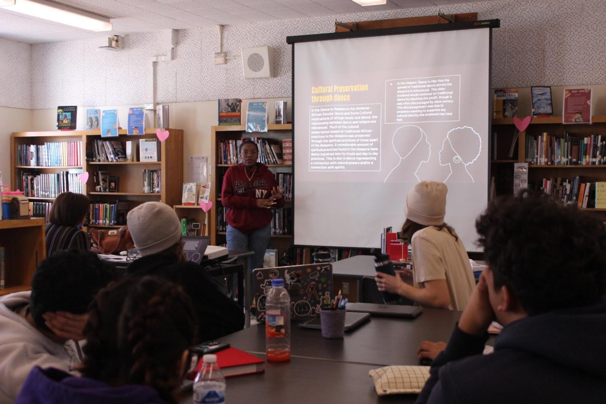 Alumna Madyson Phillips presents her research project in her AP African American Studies class during period 3 on Feb. 22. Students had to make a presentation on African American culture and present it to the class. 