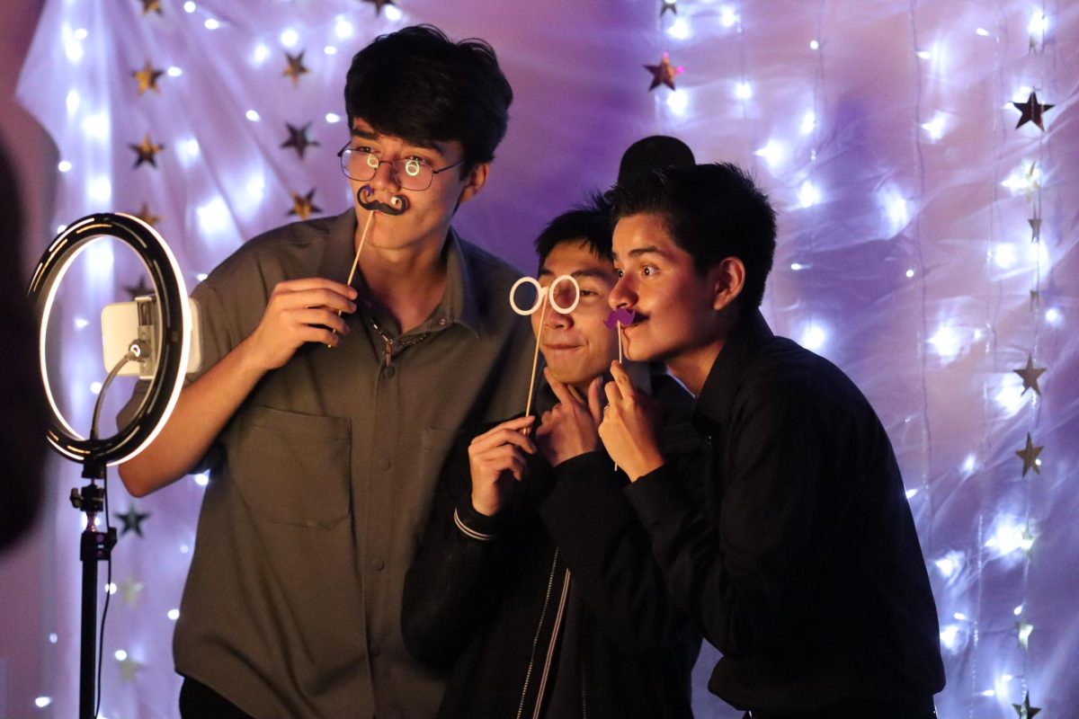 Seniors Saman Sepehr, Aidan Ly and Diego Vera-Suarez make silly faces as they take selfies at the photo booth during the homecoming dance on Oct. 18.