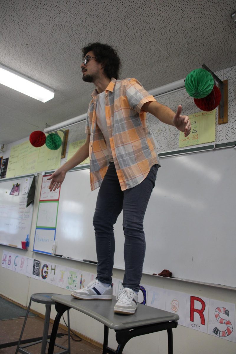 Math teacher Goncalo Sousa stands on classroom tables to show their effectiveness and sturdiness during a lockdown drill during his period 5 pre-calculus class on Sept. 11. Some students worried the tables would break under pressure.