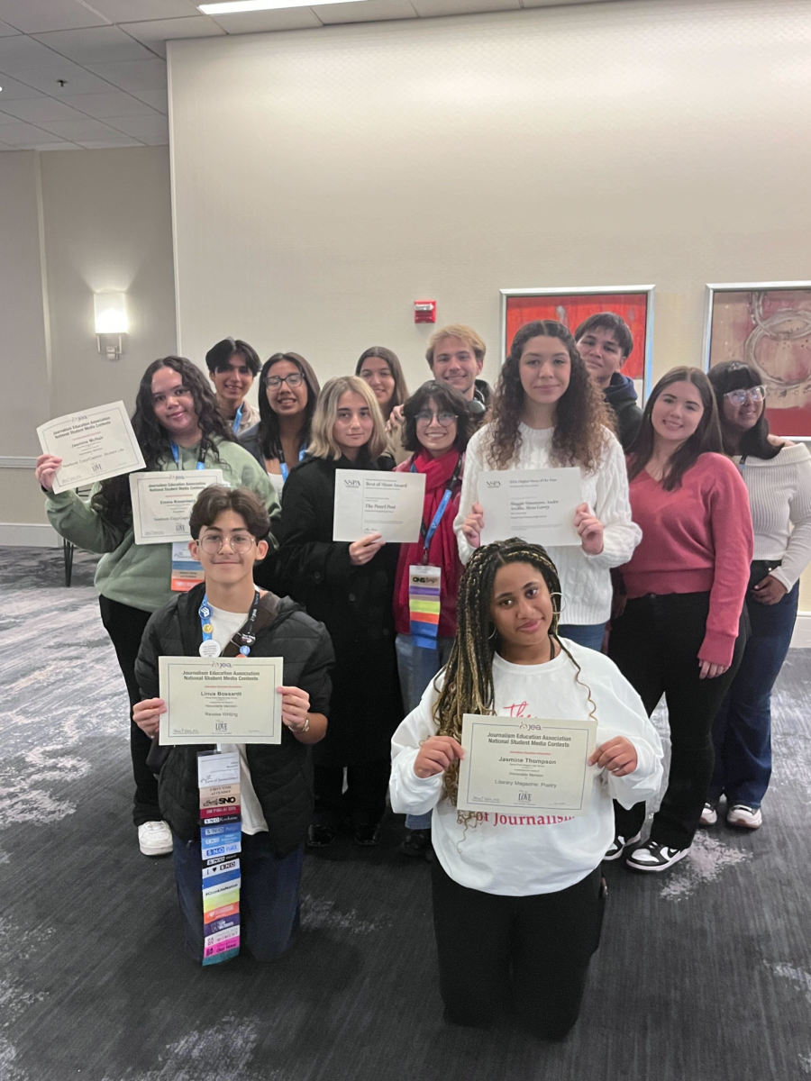 The Pearl Post staff holds up the publication's Best of Show awards and individual awards from the Student Media Contests on Nov. 10 after the Journalism Education Association awards ceremony.