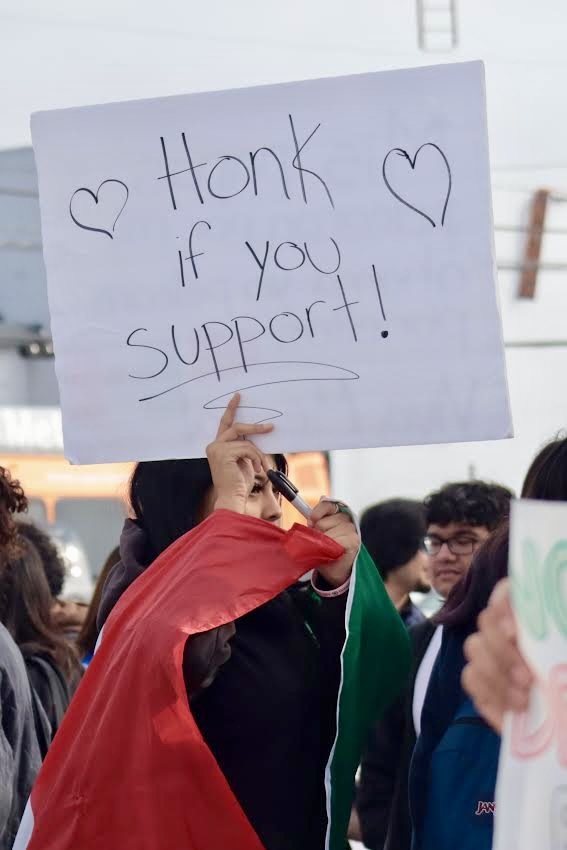 A student holds up a sign that reads 'Honk if you support' on Feb. 10.  As students protested signs like these allowed cars that drove by to show their support by honking.
