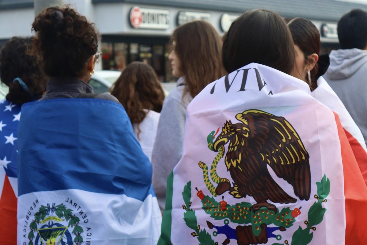 Senior Allison Gonzalez and Junior Guadalupe Martinez wrap their nationalities' flags around them as they protest against anti-immigration policies on Feb. 10.
