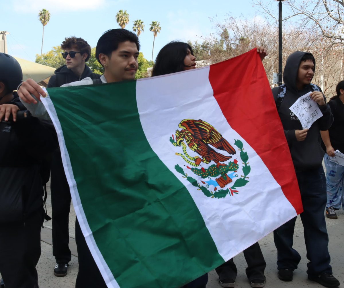 A student holds up the Mexican flag in protest of immigration policies during a walkout on Feb. 10