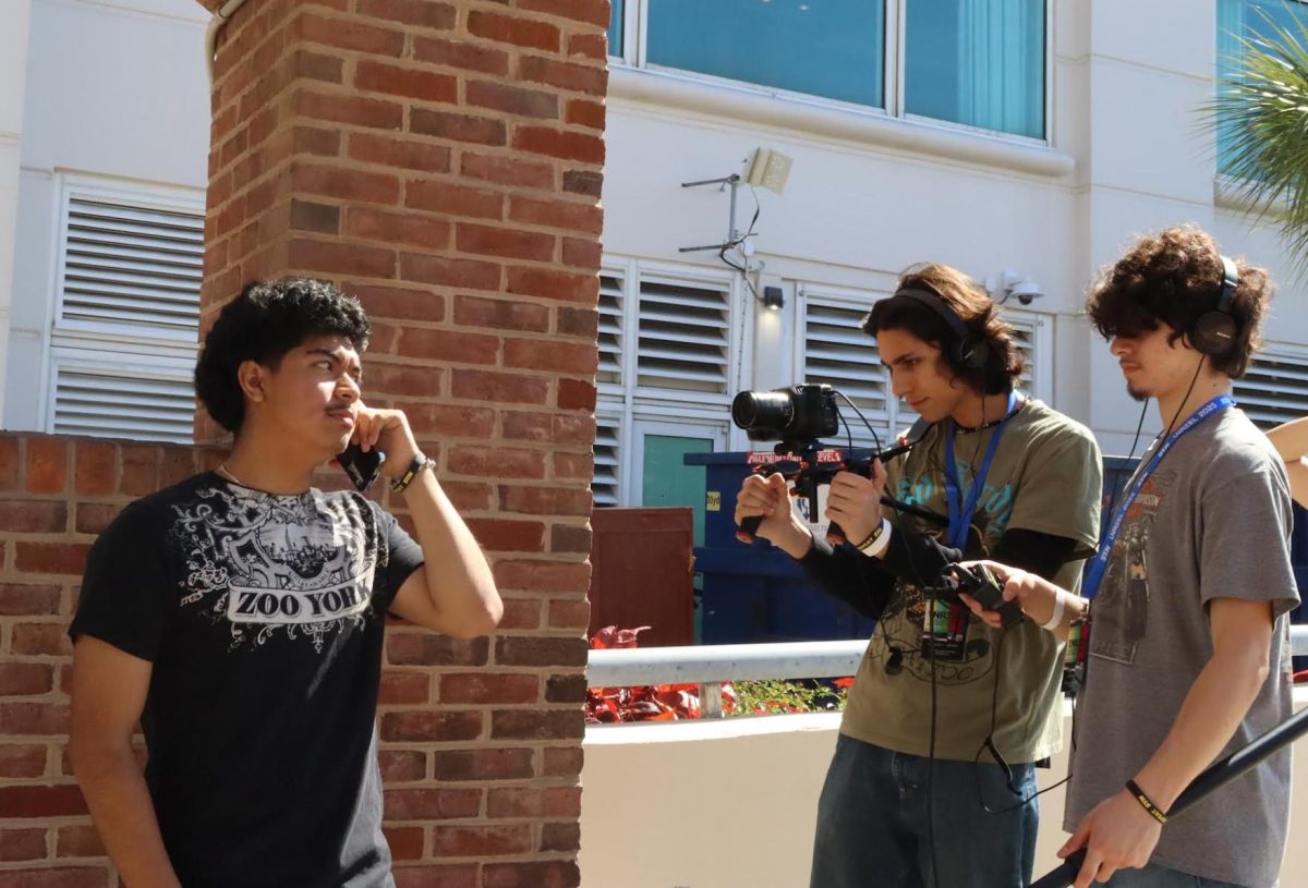 Senior Axel Aleman acts out a phone call scene while junior Sebastian Olfatmanesh and sophomore Mateo Zazueta record him on March 2. The students were competing in the short film category at the Student Televesion Network National Convention.