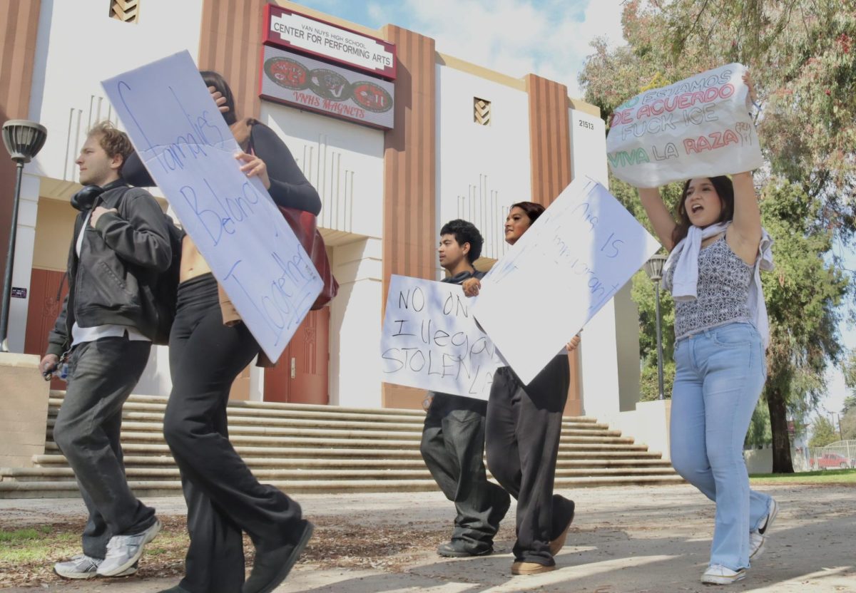 Students protest with signs as they walk in front of the Van Nuys High School Center for Performing  Arts on Feb. 10. Students from several schools, such as Daniel Pearl Magnet High School, Birmingham Community Charter High School, and Reseda Charter High School, walked out of their campuses in the morning to protest President Donald Trump's administration's current immigration policies.