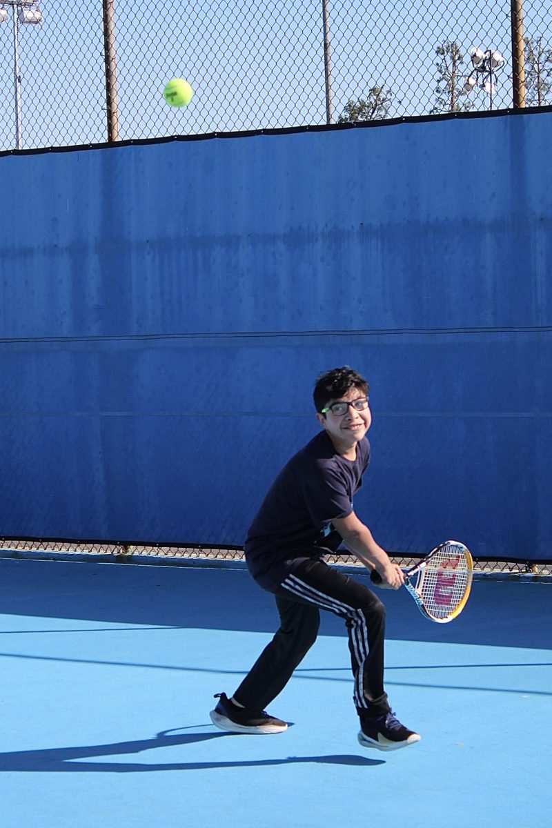 Sophomore Giancarlo Valdez backhands a tennis ball while practice at Birmingham Community Charter High School on March 3. Valdez is the only Daniel Pearl Magnet High School student on the BBCHS varsity tennis team.